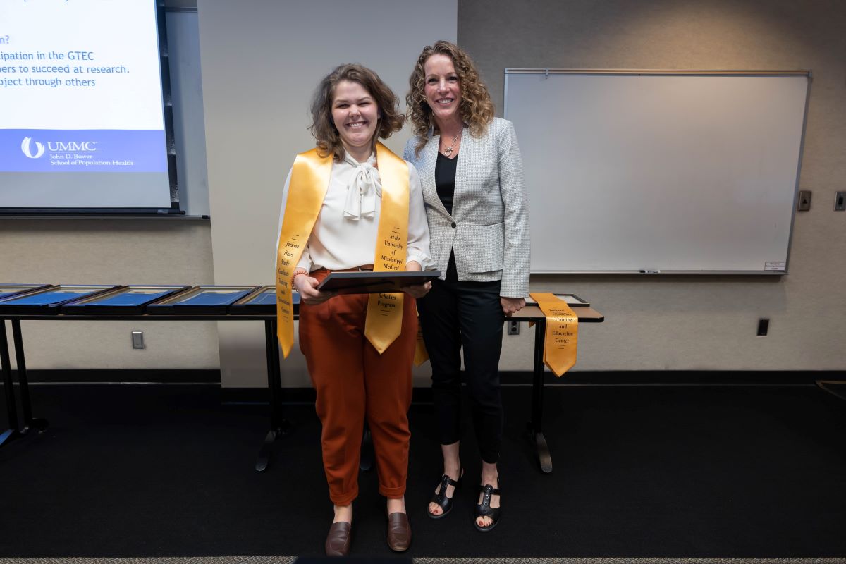 Student standing with Dr. Reneker with stole and certificate at the 2023 SOPH Research Day